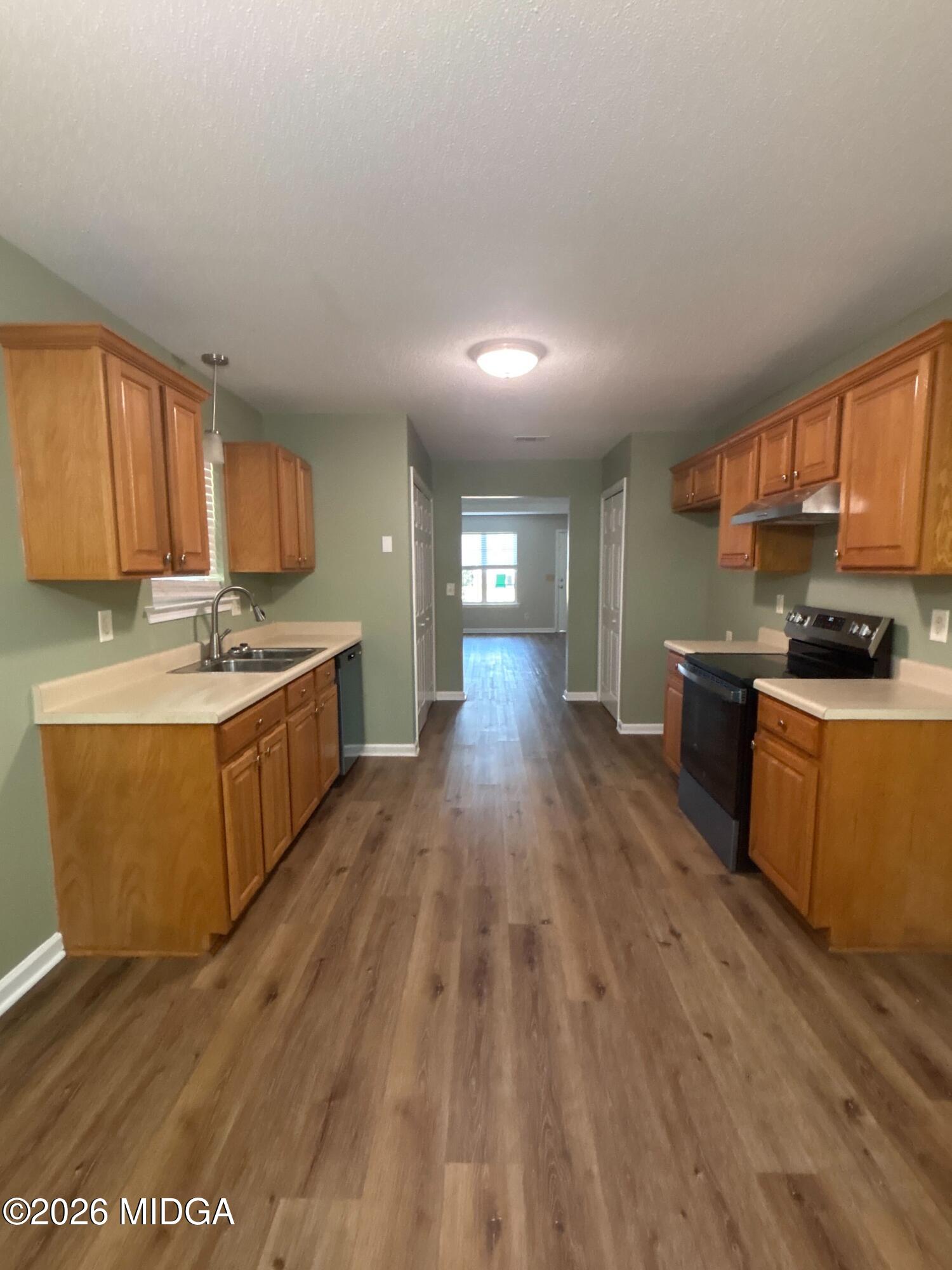 404 Dunmurry Place Warner Robins, GA 31093 - Photo 6 of 18 a kitchen with stainless steel appliances granite countertop a stove a sink dishwasher and a refrigerator with wooden floor