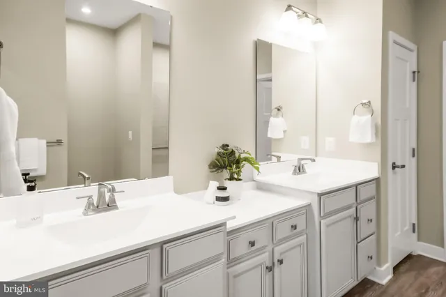 a bathroom with a double vanity sink mirror and shower