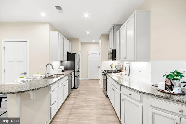 a large kitchen with stainless steel appliances lots of counter space and a sink