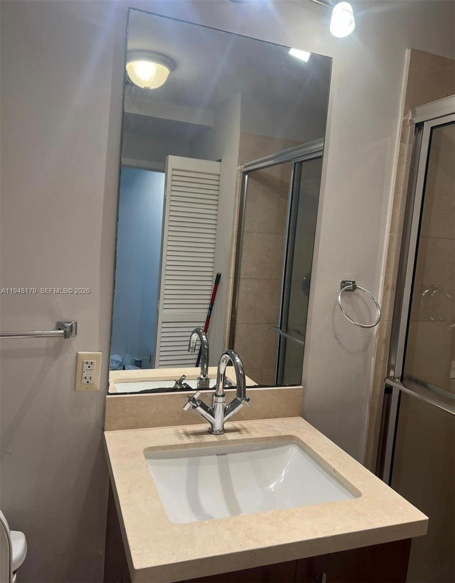 79 Southwest 12th Street, Unit 3008S Miami, FL 33130 - Photo 10 of 11 a bathroom with a sink and a mirror
