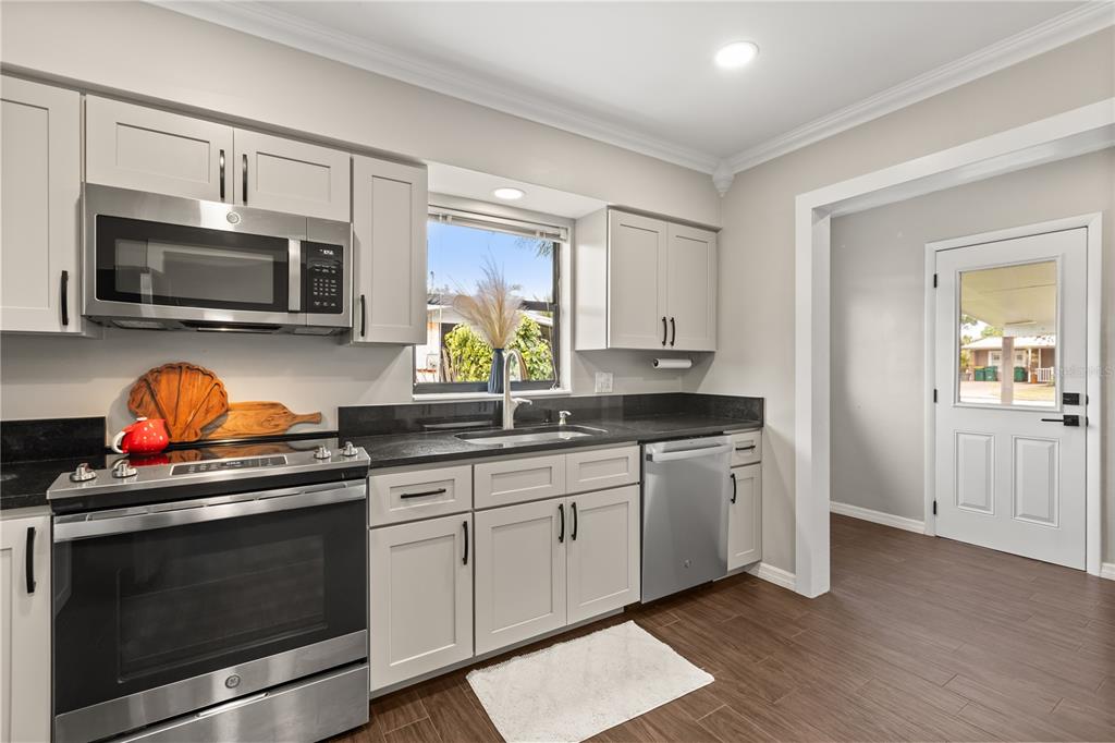 660 Java Road Cocoa Beach, FL 32931 - Photo 14 of 31 a kitchen with stainless steel appliances a stove microwave and sink
