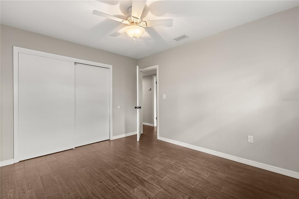 660 Java Road Cocoa Beach, FL 32931 - Photo 19 of 31 an empty room with wooden floor and fan