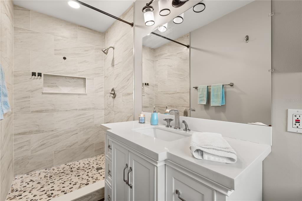 660 Java Road Cocoa Beach, FL 32931 - Photo 20 of 31 a bathroom with a sink vanity granite tub shower and a mirror