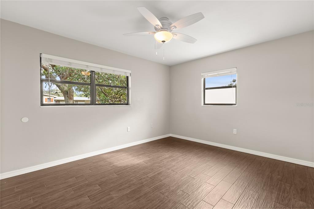 660 Java Road Cocoa Beach, FL 32931 - Photo 21 of 31 a view of an empty room with wooden floor and a window