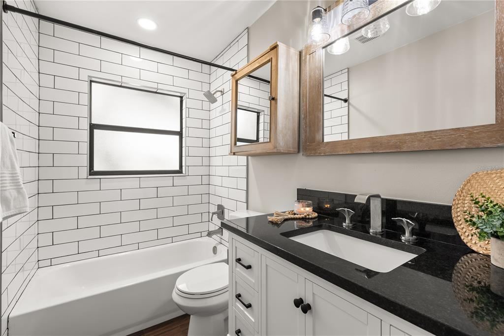660 Java Road Cocoa Beach, FL 32931 - Photo 23 of 31 a bathroom with a granite countertop sink a toilet a mirror and shower