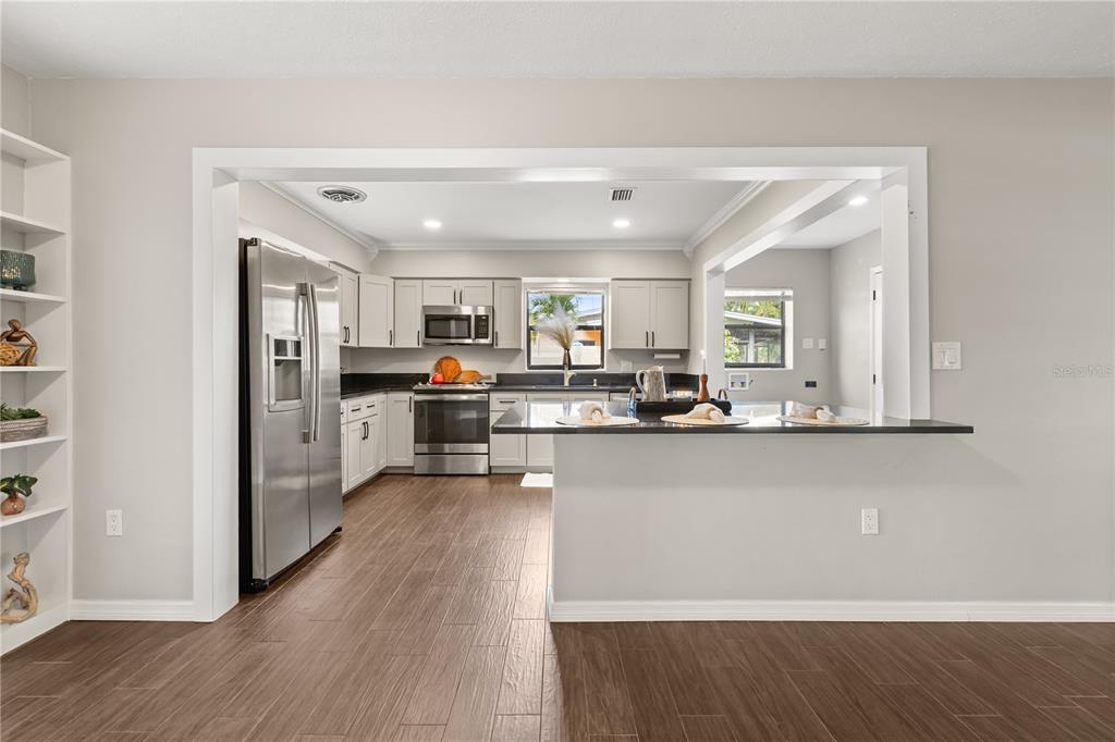 660 Java Road Cocoa Beach, FL 32931 - Photo 10 of 31 a view of a kitchen with stainless steel appliances granite countertop a refrigerator and a stove top oven