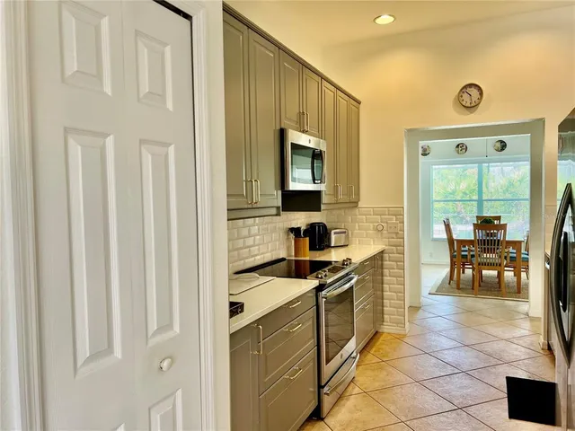 a kitchen with granite countertop a sink cabinets and stainless steel appliances