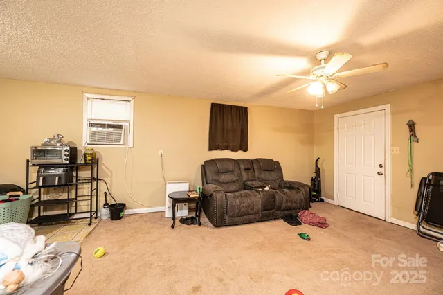 a living room with furniture a flat screen tv and gym equipment