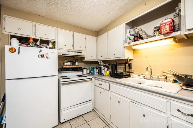 a white kitchen with sink and white appliances