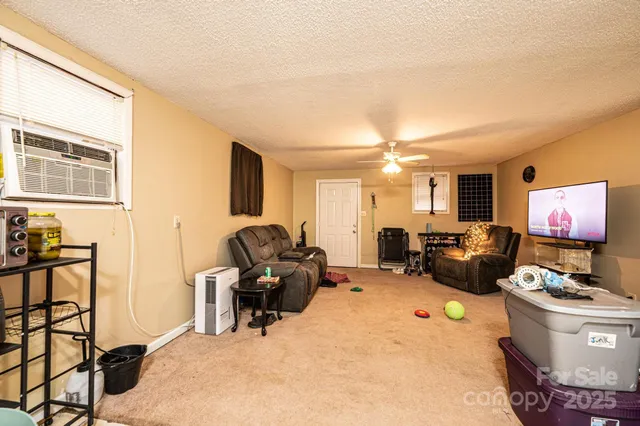 a living room with furniture a flat screen tv and kitchen view