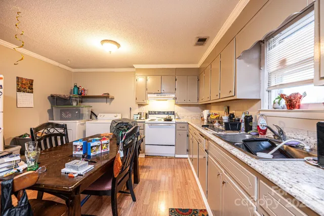 a kitchen with granite countertop lots of wooden furniture and appliances
