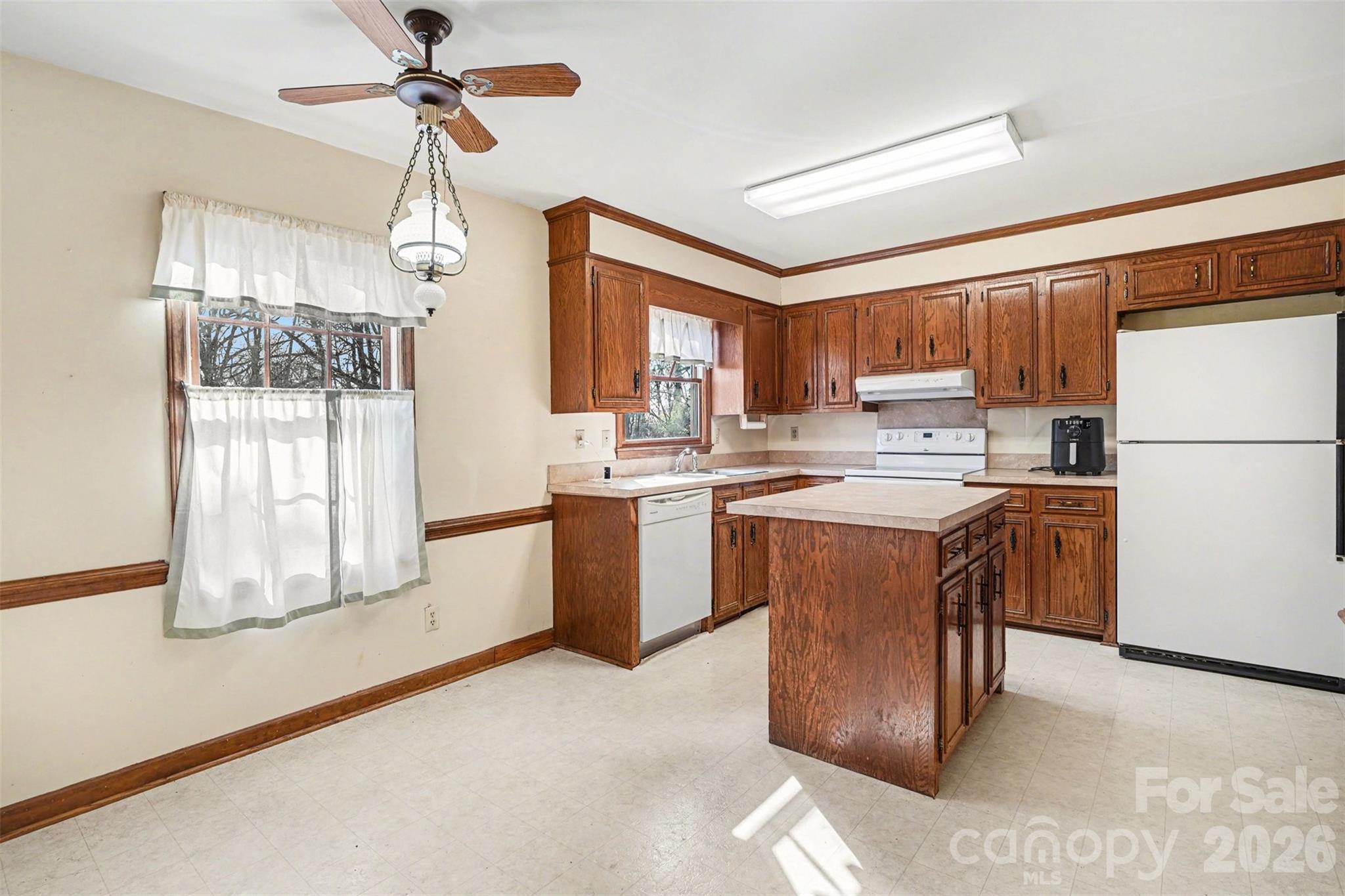 2116 Rice Road Matthews, NC 28105 - Photo 5 of 15 a kitchen with kitchen island a stove a sink a center island and a refrigerator