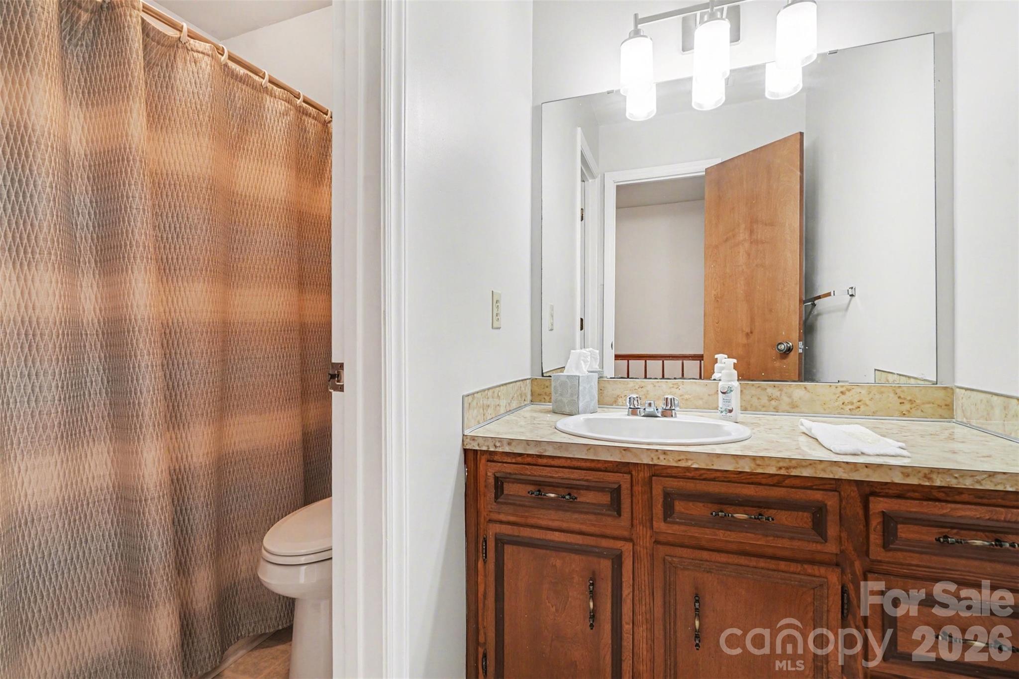 2116 Rice Road Matthews, NC 28105 - Photo 9 of 15 a bathroom with a granite countertop sink a toilet and a mirror