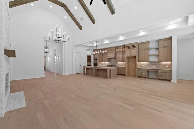 a view of a kitchen with stainless steel appliances granite countertop a stove and a wooden floors
