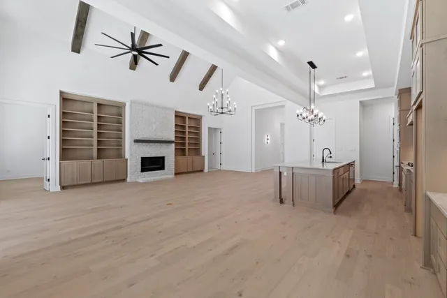 a view of an empty room with a fireplace and a window