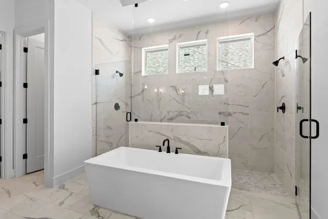 a large bathroom with a double vanity sink a mirror a bathtub and shower