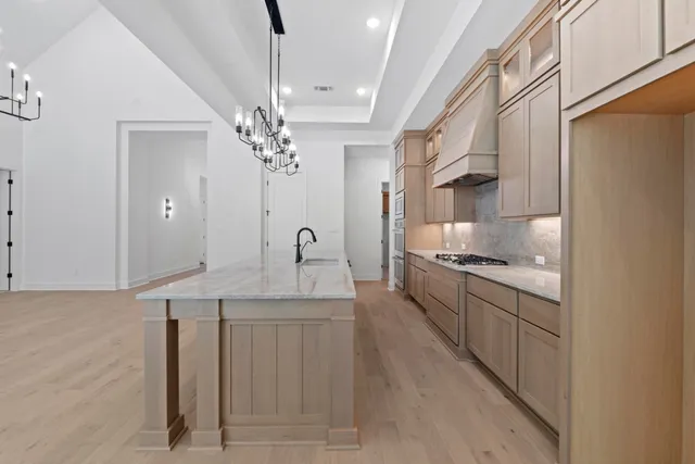 a large kitchen with granite countertop a sink stainless steel appliances and cabinets