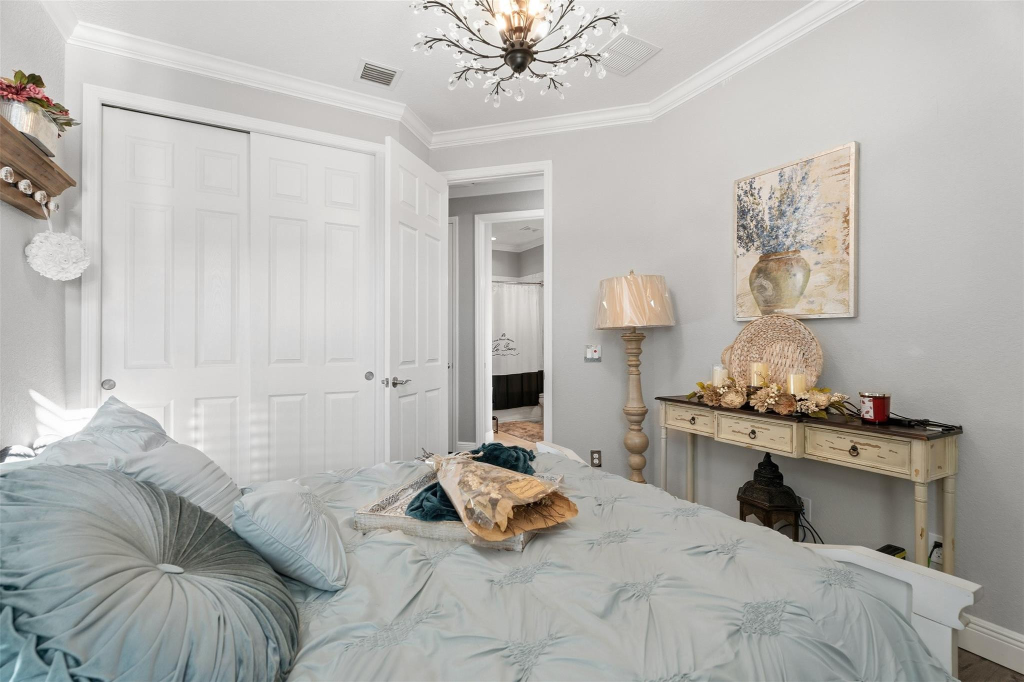 651 Southwest Glen Crest Way, Unit 2 Stuart, FL 34997 - Photo 21 of 41 a bedroom with a bed and a chandelier