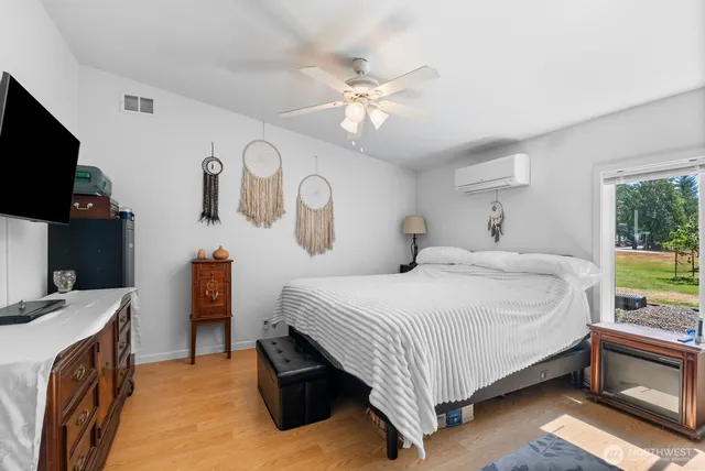 a bedroom with a bed and a flat tv screen on dresser