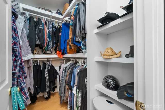 a view of walk in closet with clothes and shoes