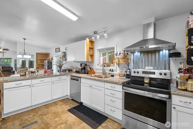 a kitchen with a stove and white cabinets