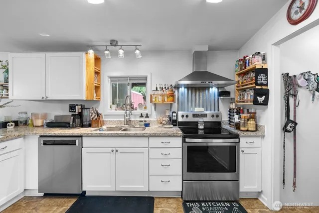 a kitchen with stainless steel appliances granite countertop a stove and white cabinets
