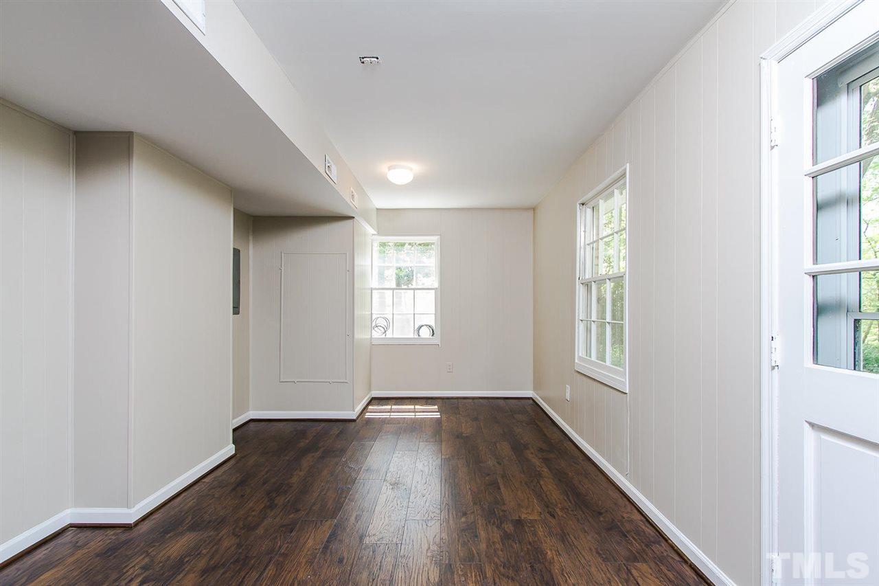 7617 Elliot Drive Raleigh, NC 27613 - Photo 14 of 25 an empty room with wooden floor and windows