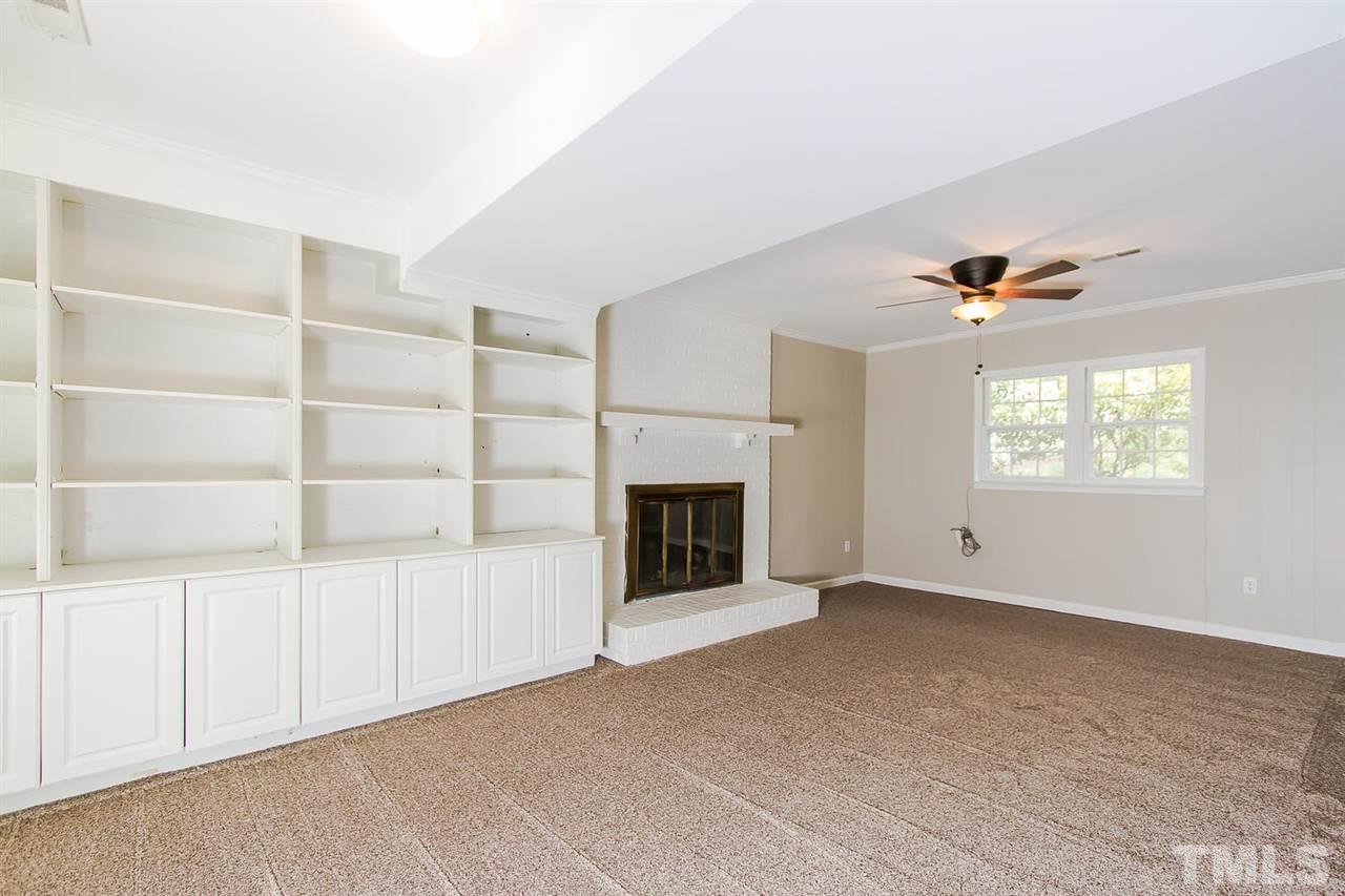7617 Elliot Drive Raleigh, NC 27613 - Photo 17 of 25 a view of an empty room with a fireplace and a window