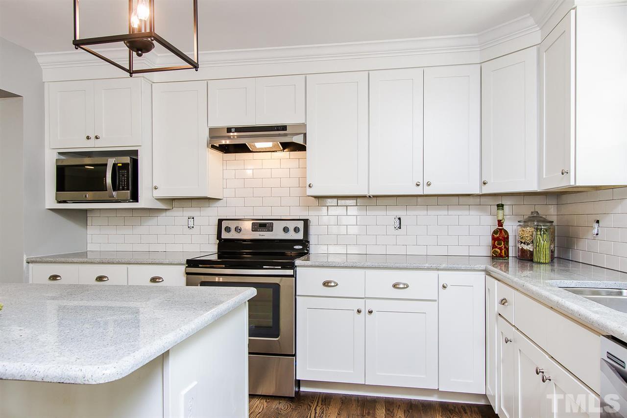 7617 Elliot Drive Raleigh, NC 27613 - Photo 8 of 25 a kitchen with stainless steel appliances granite countertop a sink a stove and a microwave