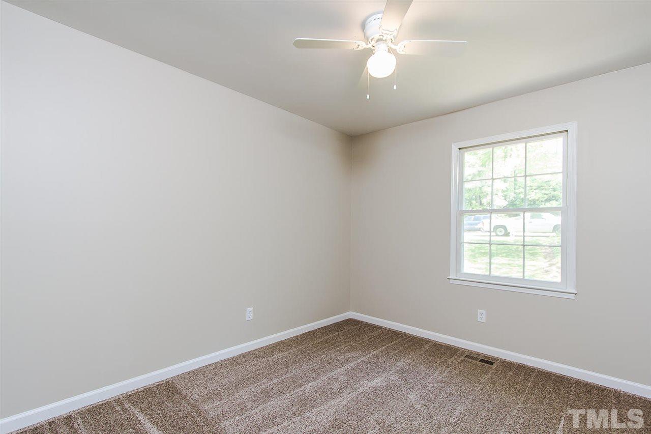 7617 Elliot Drive Raleigh, NC 27613 - Photo 9 of 25 an empty room with a window and a fan