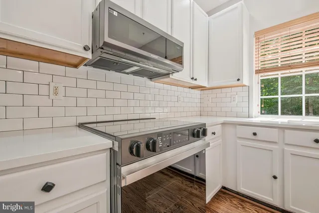a kitchen with a stove and white cabinets