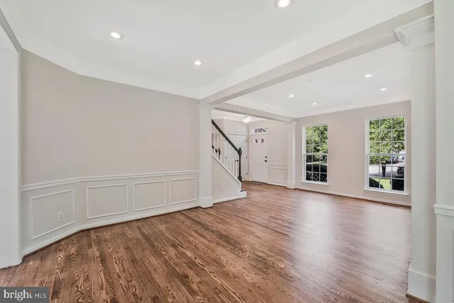a view of an empty room with wooden floor and entryway