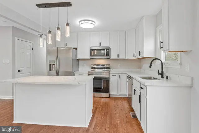 a kitchen with stainless steel appliances a refrigerator sink and microwave
