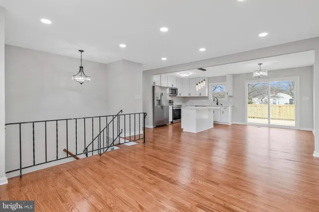 a view of an empty room with wooden floor and windows
