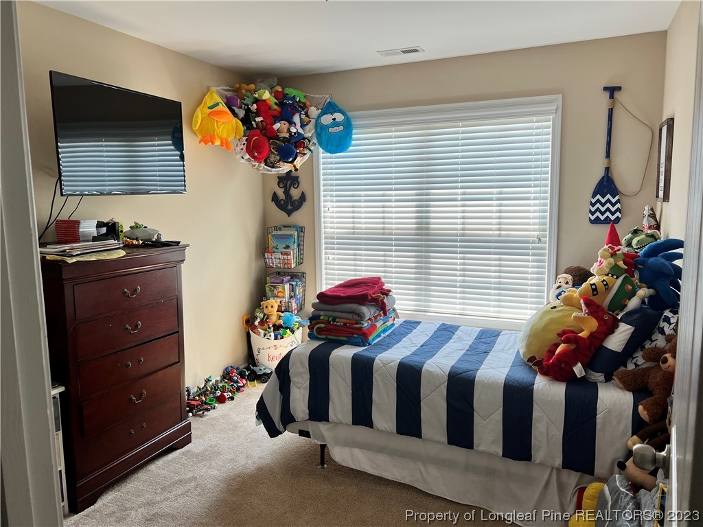 73 Blue Bay Lane Cameron, NC 28326 - Photo 26 of 42 a bedroom with a bed and a chandelier
