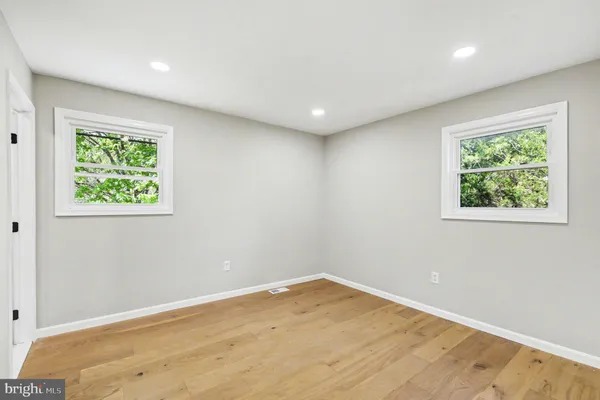 a kitchen with stainless steel appliances granite countertop a refrigerator oven a sink dishwasher and white cabinets with wooden floor