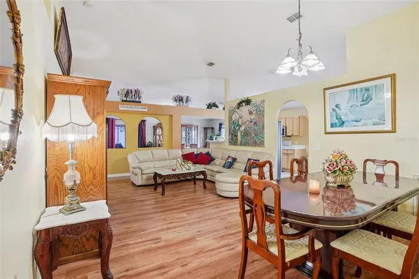 a view of a dining room with furniture a chandelier and wooden floor