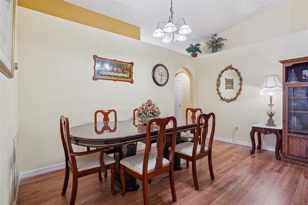 2315 Belfry Way Mascotte, FL 34753 - Photo 15 of 55 a view of a dining room with furniture a chandelier and wooden floor