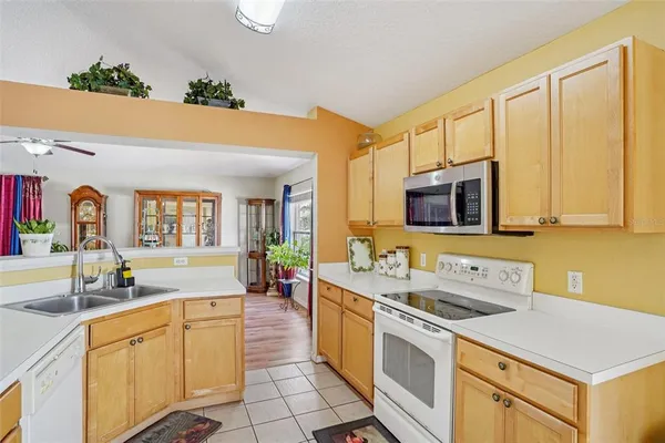 a white kitchen with a sink and chandelier
