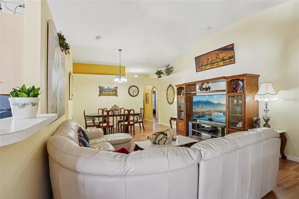 a living room with furniture a piano and a flat screen tv