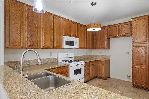 a kitchen with stainless steel appliances granite countertop a stove a sink dishwasher and a microwave