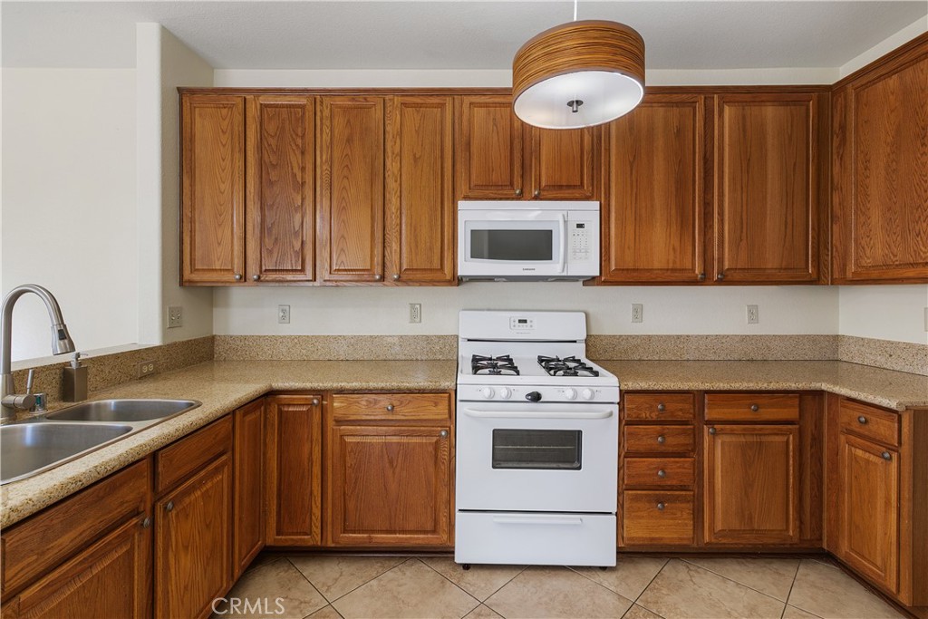 93 Kansas Street, Unit 202 Redlands, CA 92373 - Photo 16 of 40 a kitchen with stainless steel appliances granite countertop a stove a sink dishwasher and a microwave