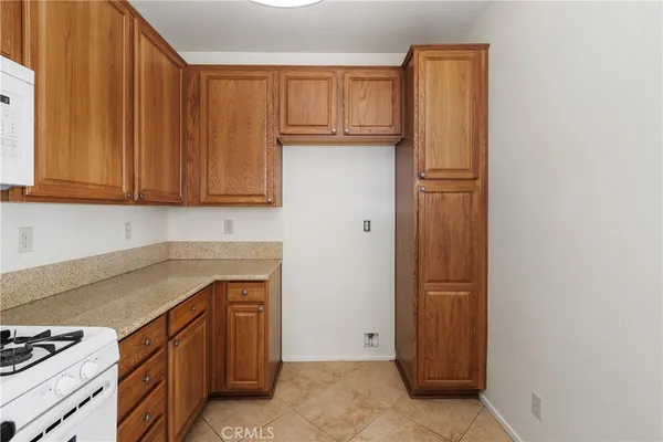 a kitchen with granite countertop a sink a stove and cabinets