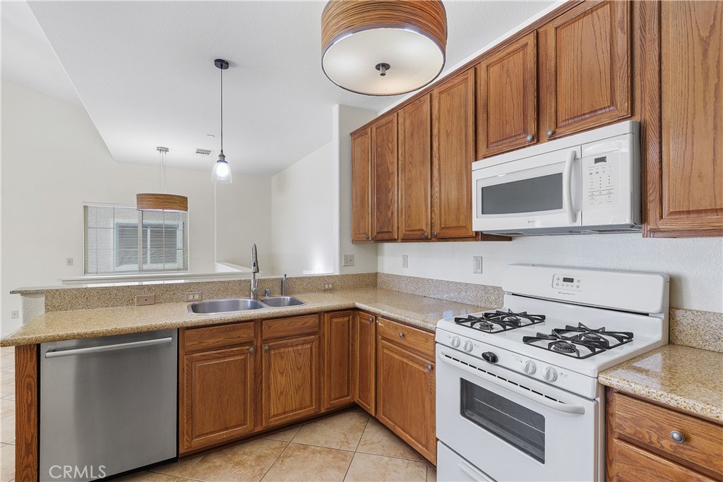93 Kansas Street, Unit 202 Redlands, CA 92373 - Photo 18 of 40 a kitchen with granite countertop a sink a stove and cabinets