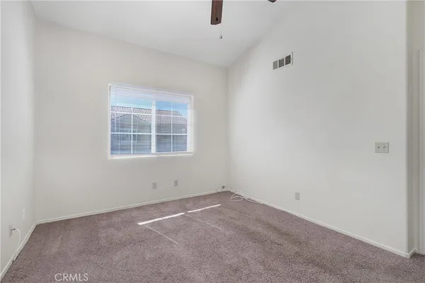 an empty room with chandelier fan