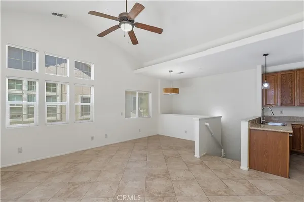 a view of a livingroom with a fireplace a ceiling fan and wooden floor