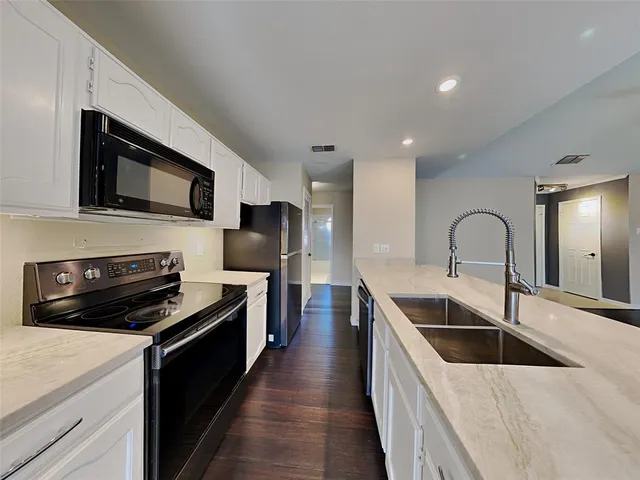 a kitchen with stainless steel appliances a stove sink and microwave