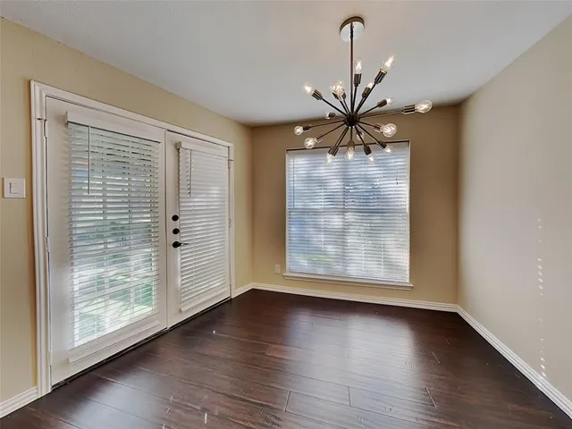 a view of a livingroom with a large window wooden floor and a chandelier