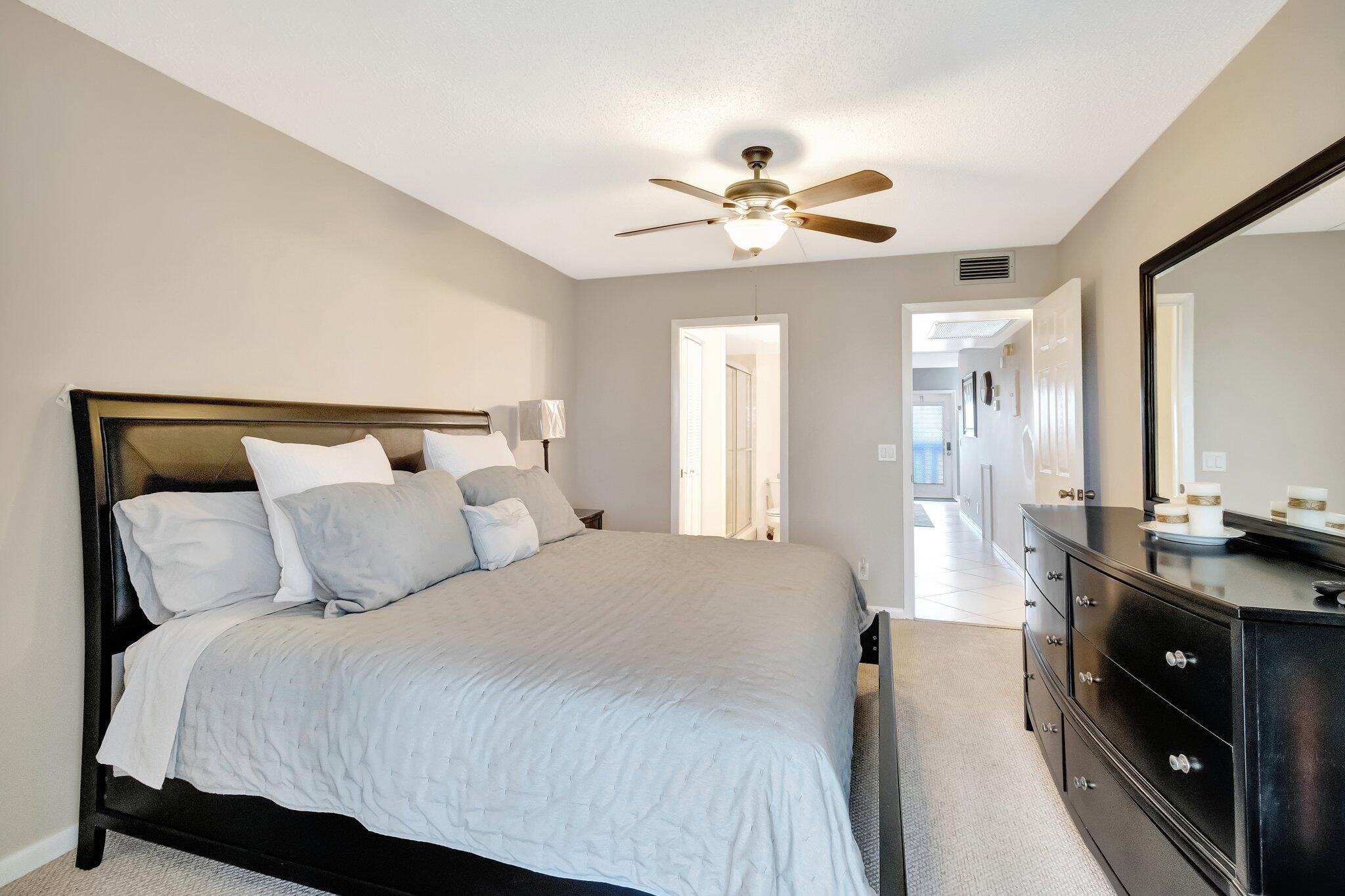 4049 Wolverton C Boca Raton, FL 33434 - Photo 23 of 88 a bedroom with a bed and a chandelier