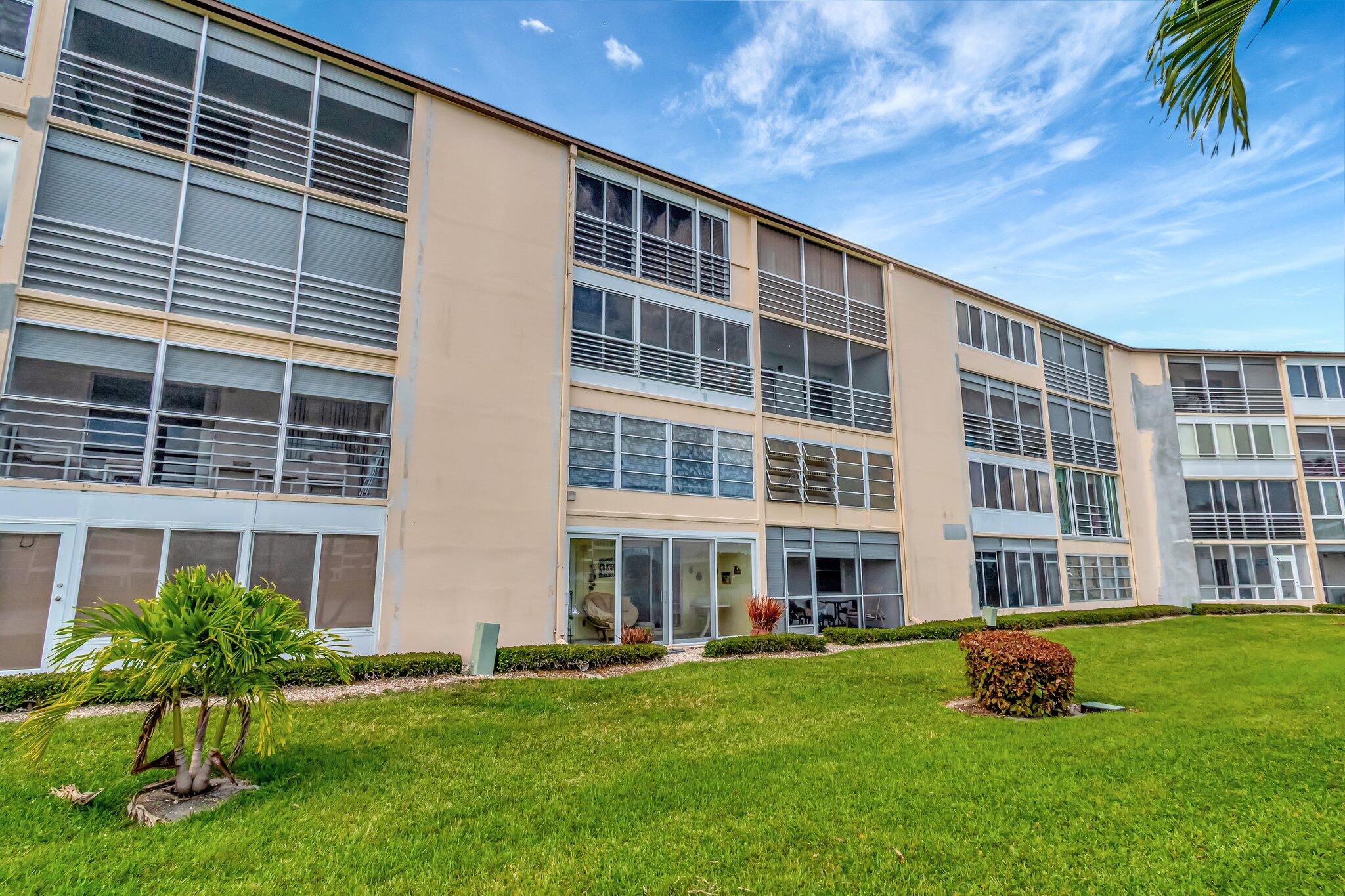 4049 Wolverton C Boca Raton, FL 33434 - Photo 40 of 88 a front view of a building with a garden
